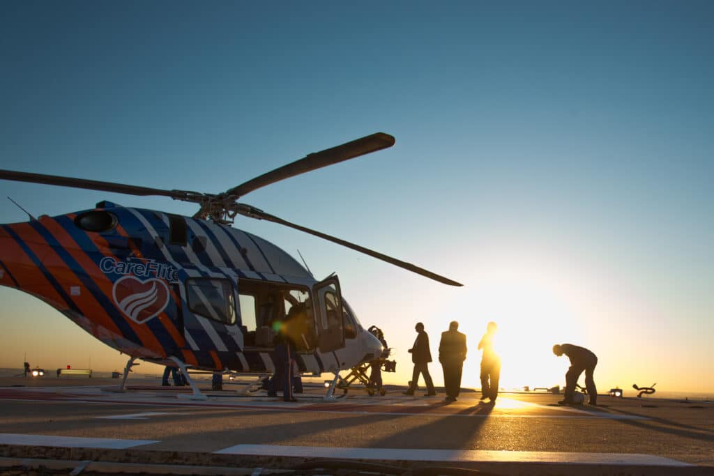 A photo of the CareFlite airlift helicopter with a few people standing next to it.