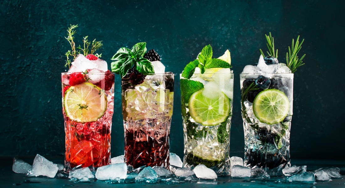 An assortment of colorful beverages in tall clear glasses, used to explain reducing alcohol intake with mocktails