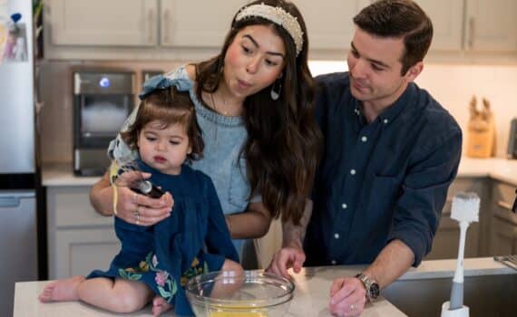 Alexandria Hurst, her husband Micah, and baby Aniston cooking together in their kitchen