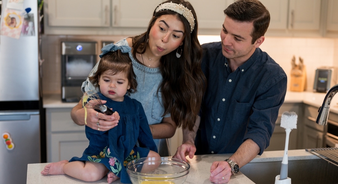Alexandria Hurst, her husband Micah, and baby Aniston cooking together in their kitchen