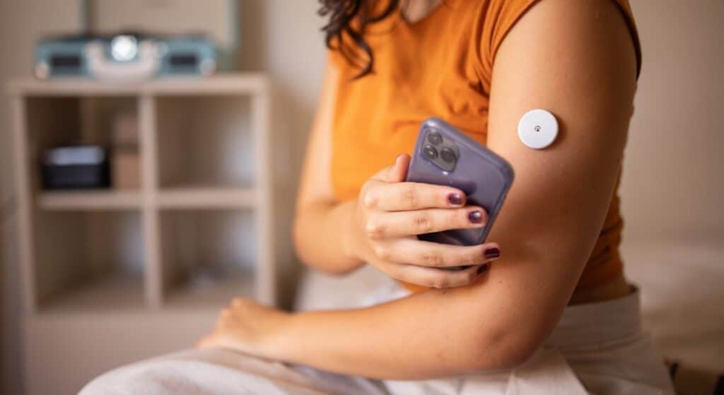 A woman wearing an insulin patch for managing diabetes on her arm, used to explain managing type 2 diabetes