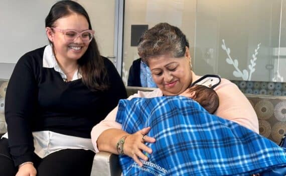 Joanna Navarette standing behind her mother, Maria, who holds Joanna's newborn, Jacob Jr., at Methodist Dallas Medical Center after Joanna donated a kidney to Maria
