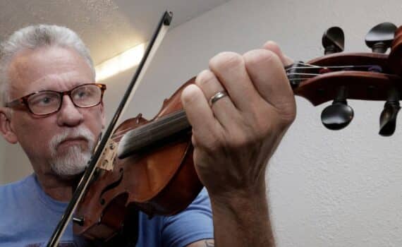 Tim Odom playing a string instrument after his sleep apnea implant procedure at Methodist Dallas Medical Center