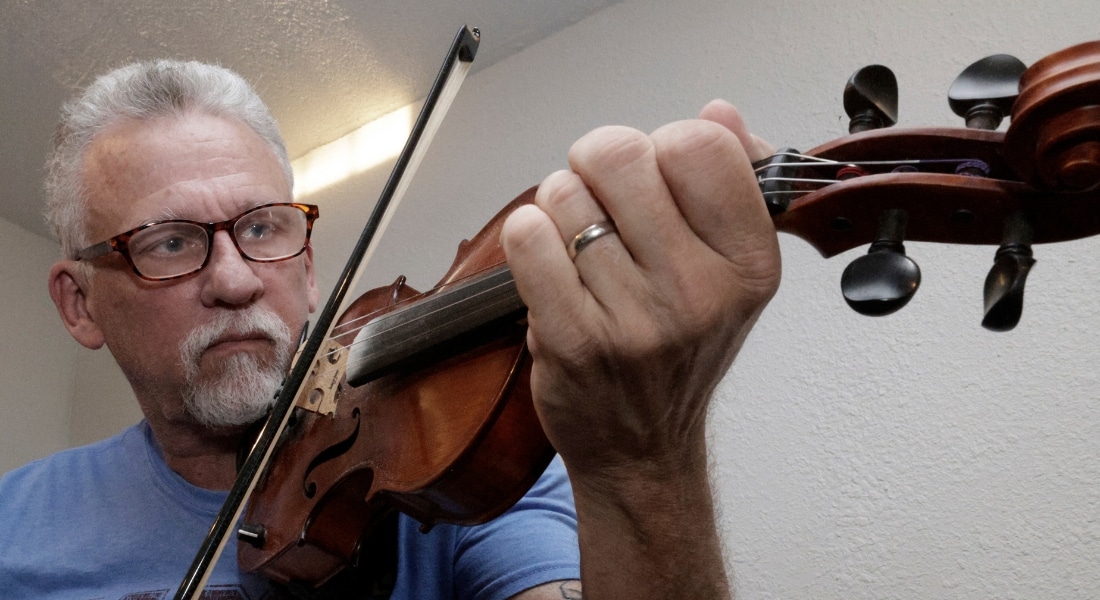 Tim Odom playing a string instrument after his sleep apnea implant procedure at Methodist Dallas Medical Center