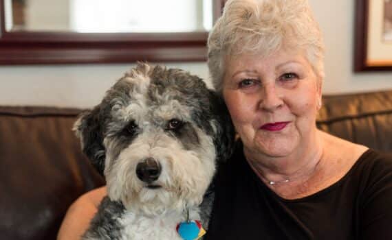 A woman named Wendy Aschner photographed with her Bernedoodle, Bandit, after Wendy's close call with a pulmonary embolism