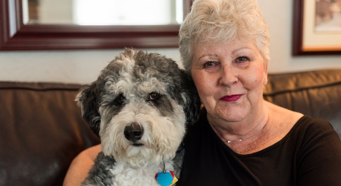 A woman named Wendy Aschner photographed with her Bernedoodle, Bandit, after Wendy's close call with a pulmonary embolism