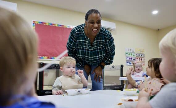 A woman named Karol Fuget poses for a photo with children at the daycare she runs.