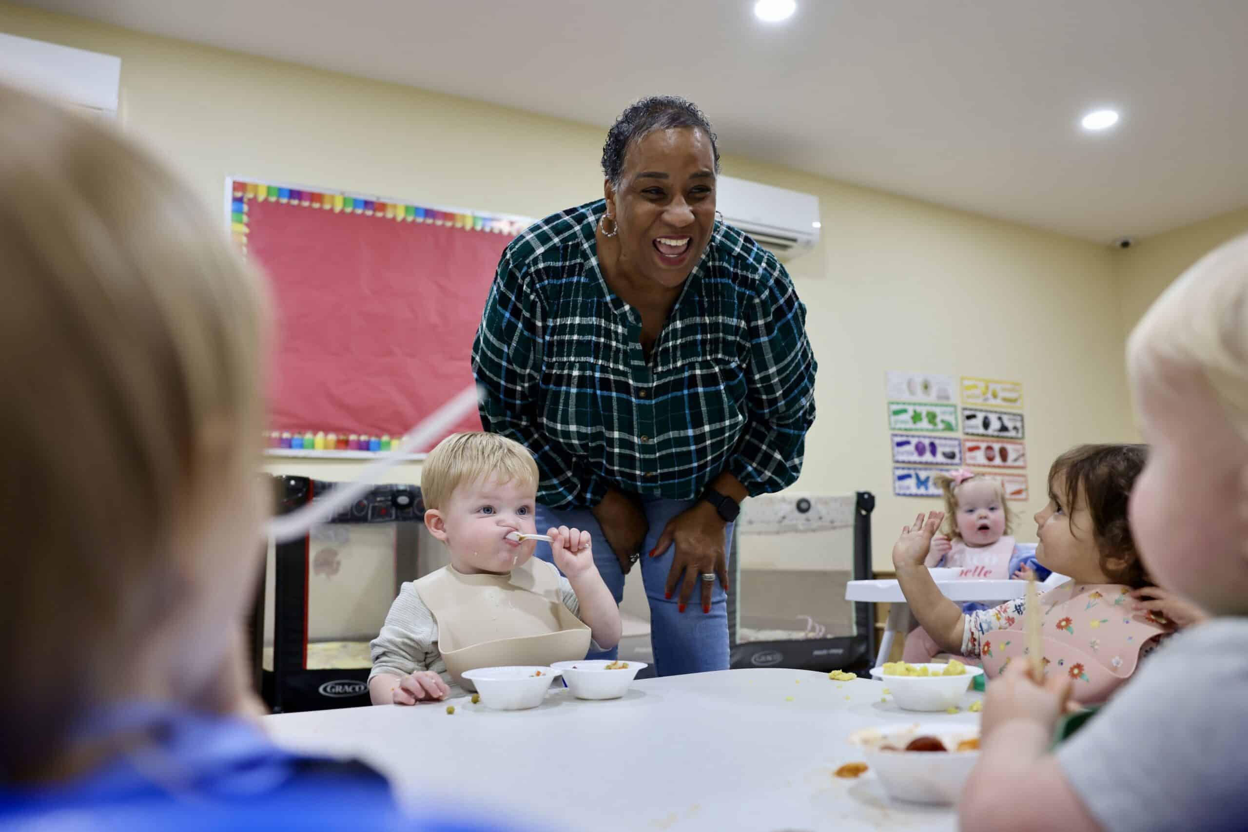 A woman named Karol Fuget poses for a photo with children at the daycare she runs.