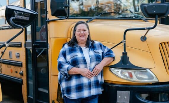 Delonda Faltesek standing beside a school bus at Oak Park School.