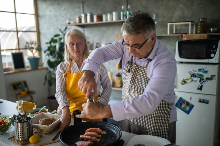 Senior couple preparing healthy meal together at home.