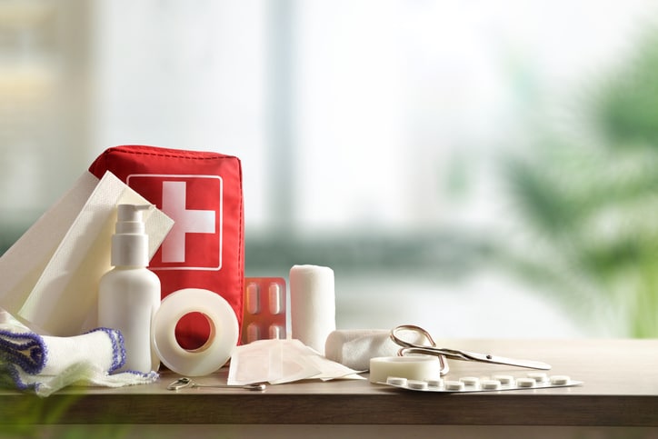 Emergency home kit on wooden table and warm room background. Horizontal composition. Front view.