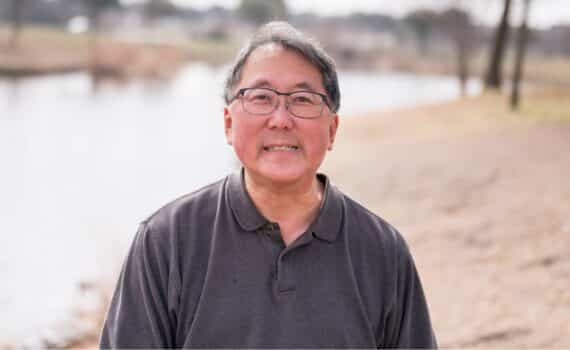 Heart patient Richard Chin stands beside a pond near his home in Sachse.