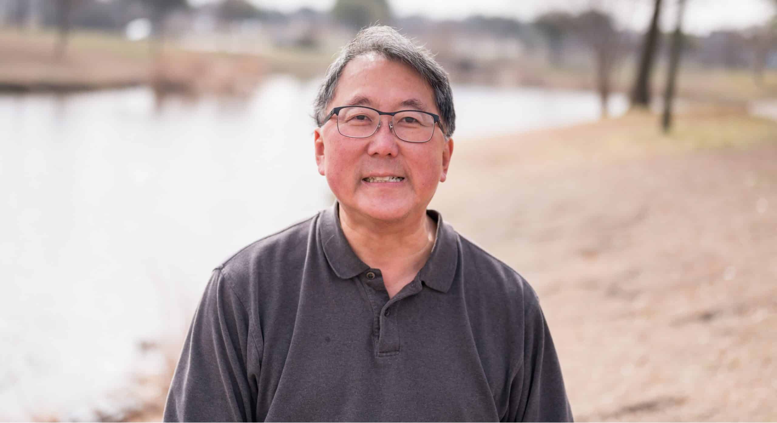 Heart patient Richard Chin stands beside a pond near his home in Sachse.