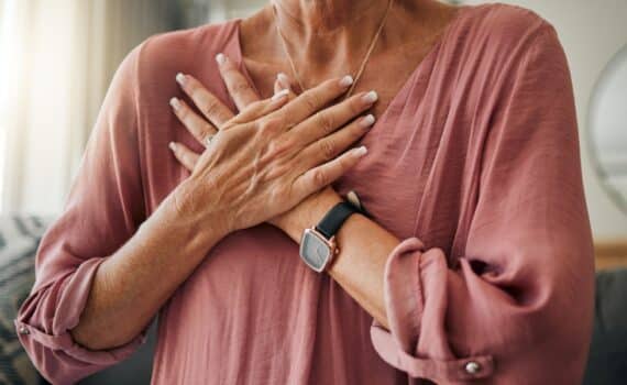 A woman clutches her chest during a heart attack.