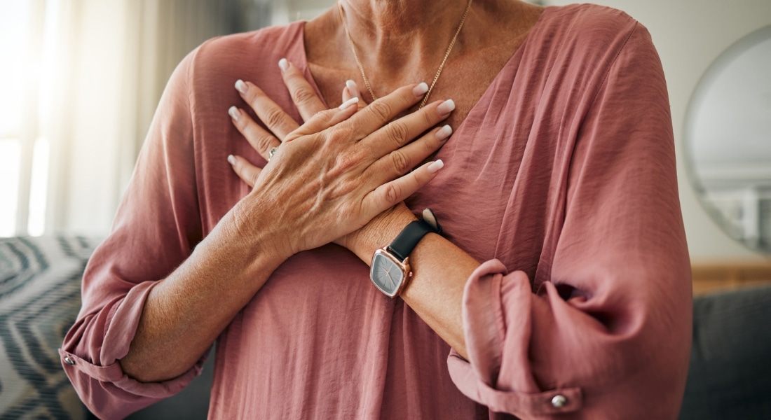 A woman clutches her chest during a heart attack.