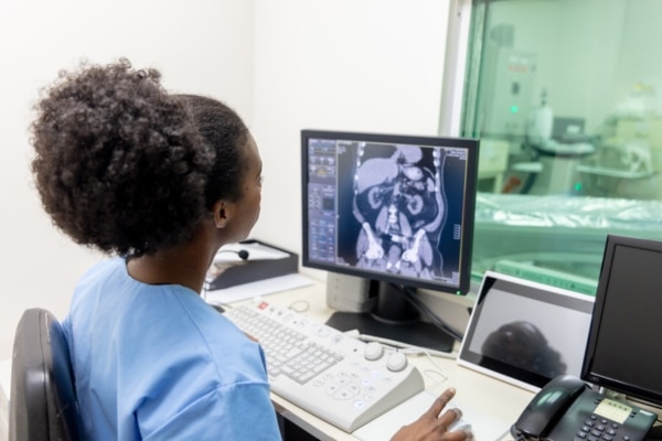 A radiology technician monitors a CT scan.