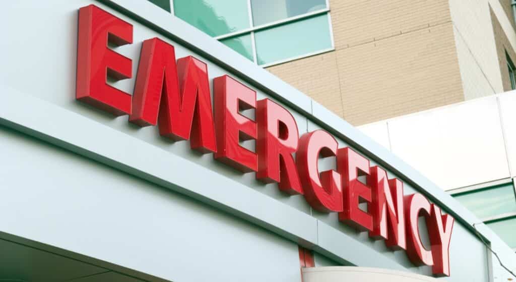 A sign over a hospital ER entrance reads "emergency."