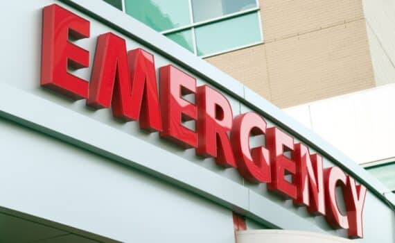 A sign over a hospital ER entrance reads "emergency."