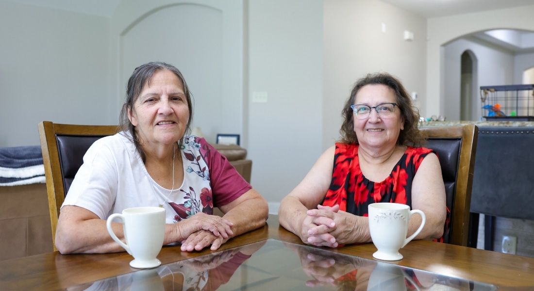 Heart patients Mary Stierhoff and Carmen Alfaro share cups of coffee at their dining room table.