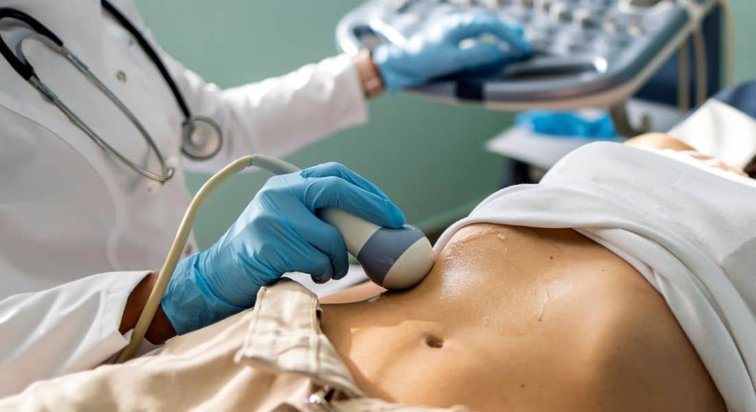 A doctor performs an ultrasound to detect pancreatic cancer in a female patient.