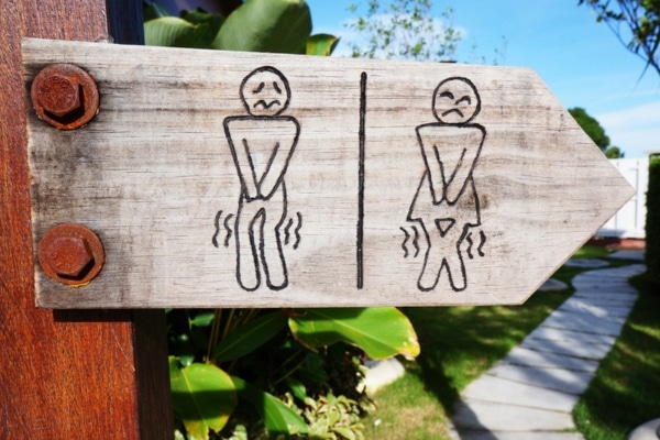 A stylized restroom sign shows diagrams of a man and woman urgently needing to go.