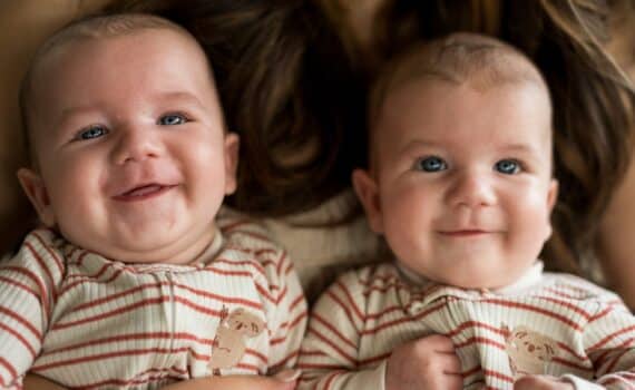 Newborn twins Henry and Harvey Coleman sit on their mother's lap.