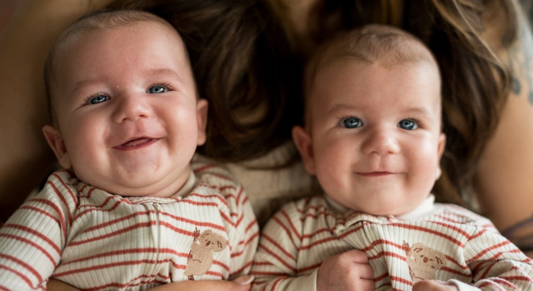 Newborn twins Henry and Harvey Coleman sit on their mother's lap.