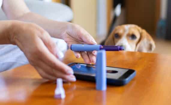 A woman consults her doctor by phone while using a GLP-1 injector.