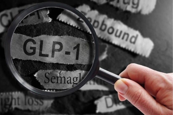 GLP-1 related drugs newspaper headlines with hand and magnifying glass