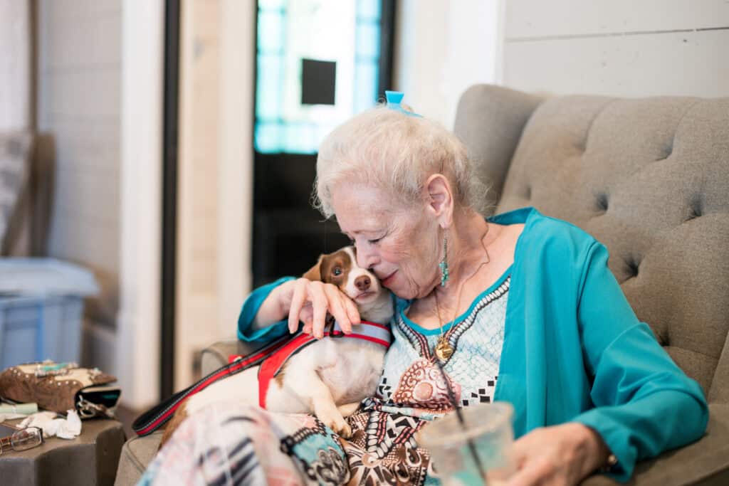 DVT patient Sharron Mirikitani hugs her emotional support dog patches.