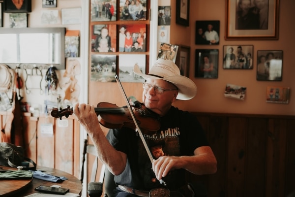 Pake McEntire plays the fiddle in a room surrounded my pictures and mementos of his famous family.