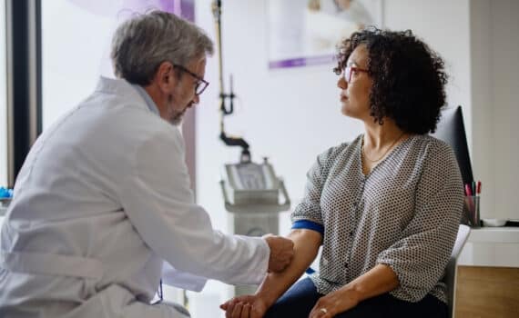 A doctor takes a blood test from a female patient.
