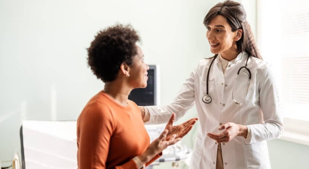 A woman in her 40s discusses menopause concerns with her doctor.