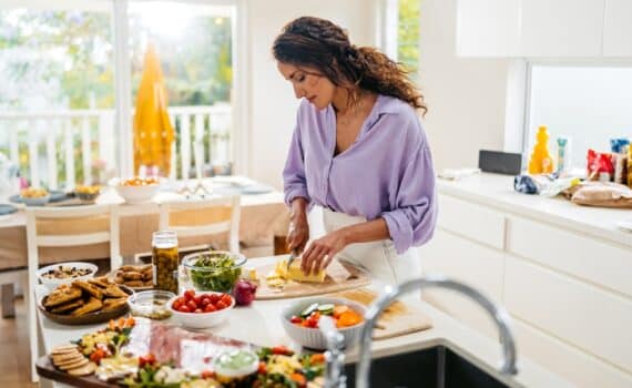 A woman in her 40s prepares a meal in her kitchen