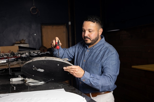 Eddie Conde repairs a sign at his Midlothian restaurant.