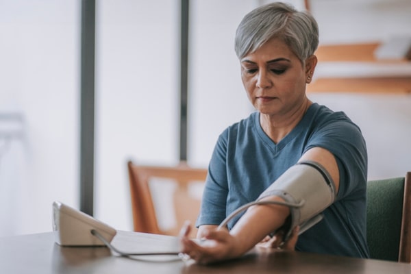 An older woman checks her blood pressure