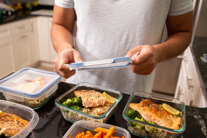Man putting away meal prep containers Salmon