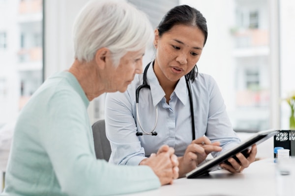 Older woman speaks to doctor about inflammatory bowel disease.