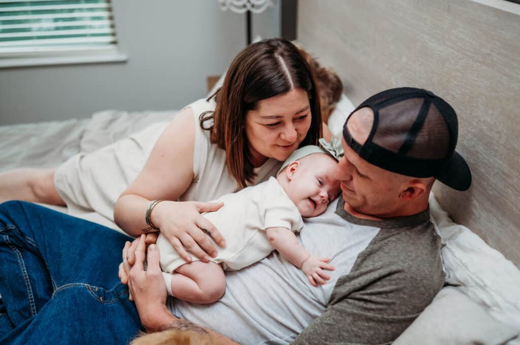 Emile and Kyle DeWald lie in bed with their preemie Poppy.