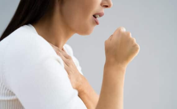 Unrecognizable woman coughing while suffering with GERD