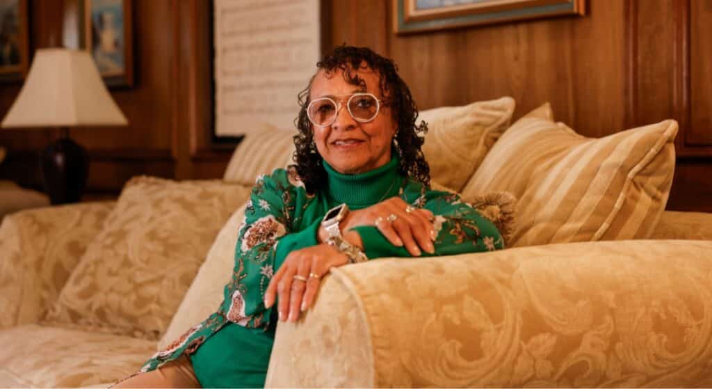Heart attack survivor Deborah Williams sits on a couch at her Arlington home.