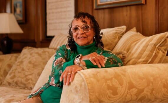 Heart attack survivor Deborah Williams sits on a couch at her Arlington home.