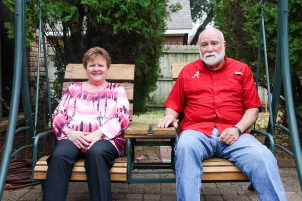Kimberley sits on a porch swing with her husband, Robert.
