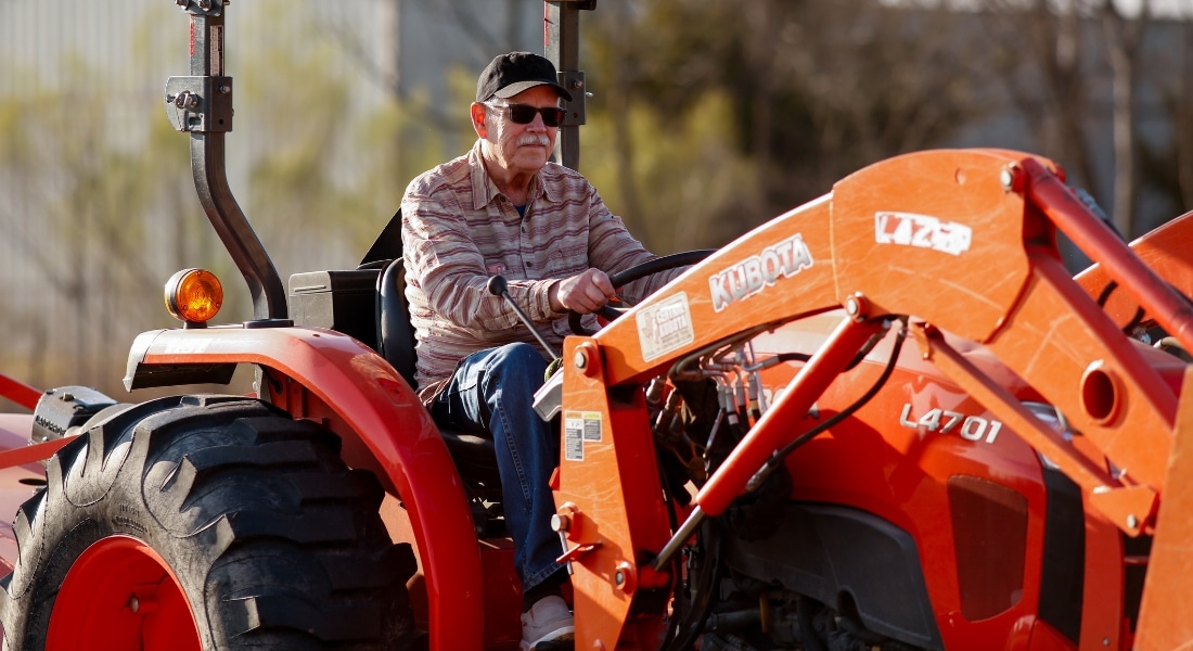 Lung cancer survivor drives a tractor on his farm in Waxahachie.