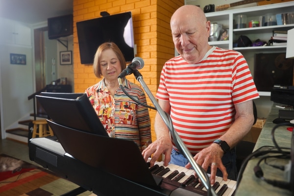 Gary Coots plays the keyboards with his wife, Barb, looking on.