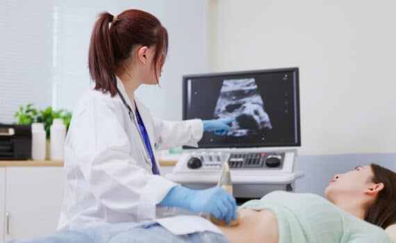 A doctor performs an ultrasound on a patient suffering from PMOS.