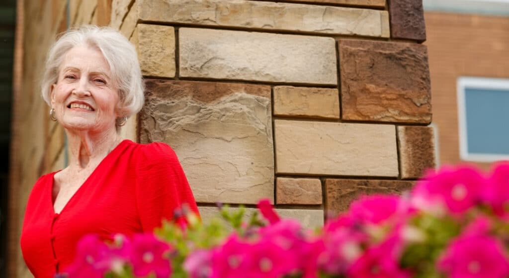 Transplant patient Linda Williams poses with flowers at Grand Central Park in Grand Prairie.