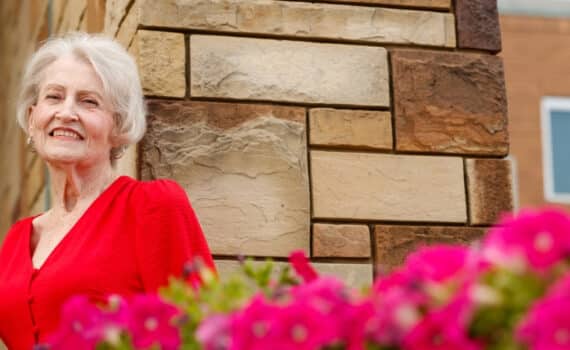 Transplant patient Linda Williams poses with flowers at Grand Central Park in Grand Prairie.