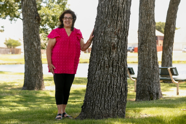 Lupe Macias leans on a tree at a park in Cedar Hill.