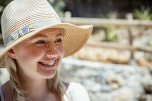 Portrait of a beautiful young caucasian woman smiling in her sunhat.